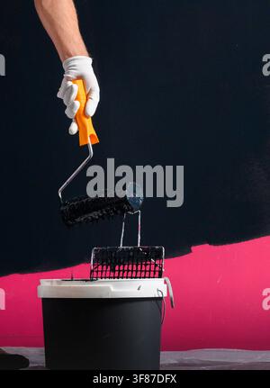 Close-up of a paint roller and paint bucket prepared for painting interior walls. Stock Photo