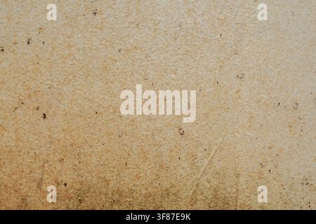 Close-up of a weathered beige surface with heavy dirt stains and water damage, creating a grungy industrial texture. Stock Photo