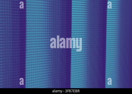 Close-up of blue and purple vertical blinds featuring a grid texture and striped lighting. Modern abstract background suitable for technology or inter Stock Photo