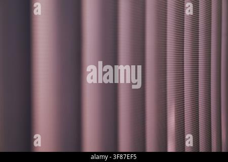 Close-up of purple vertical blinds with micro-perforated texture. Minimalist geometric pattern with selective focus for modern office or home decor ba Stock Photo