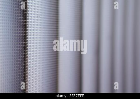 Macro shot of a geometric grid on a textured glass surface. Features a soft purple bokeh effect and shallow depth of field, perfect for minimalist bac Stock Photo