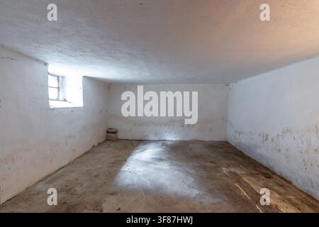 Empty concrete room showing isolation and damp conditions Stock Photo