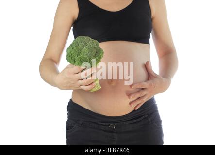 Pregnant woman holding a broccoli head, isolated on white background Stock Photo