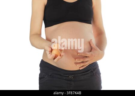 Pregnant woman holding eggs, isolated on white background Stock Photo