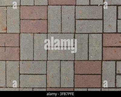 The ground displays a design made of gray and red bricks, creating a patterned surface suitable for walkways or patios. Stock Photo