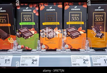 Denia, Spain - October 16, 2025.Dark chocolate bars filled with whole hazelnuts and whole almonds are displayed in a supermarket in Spain. The product Stock Photo