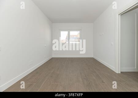 Empty Room with Window Overlooking Rooftops with Solar Panels and Wood Laminate Flooring Stock Photo
