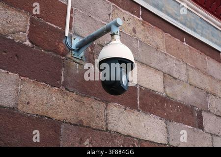 Security camera in Guangzhou city in China. CCTV equipment. Security surveillance technology on old building in Shawan district. Stock Photo