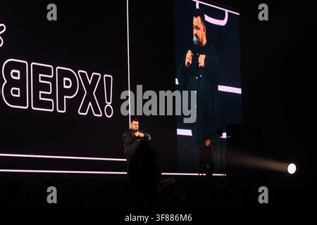 Ryazan, Russia, 28.09.2025 Man speaker holding microphone on stage. Conference presenter or stand up comedian performing with audience. Live event con Stock Photo