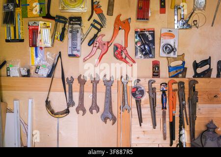Russia, Saint Petersburg, 23.08.2025 Workshop wall with various tools. Hand tools on wooden background for construction, repair, and woodworking craft Stock Photo