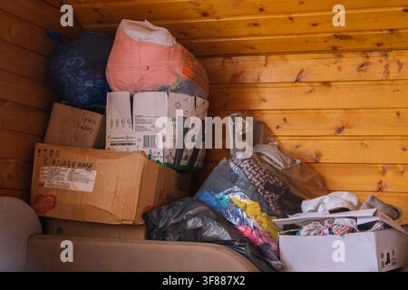 Russia, Saint Petersburg, 23.08.2025 Piled cardboard boxes and plastic bags full of various items for storage or moving day concept Stock Photo
