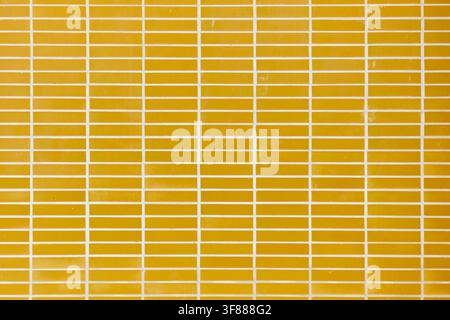 Background created with a close up of an exterior tiled wall of a building. Rectangular tiles arranged in horizontal rows. Stock Photo