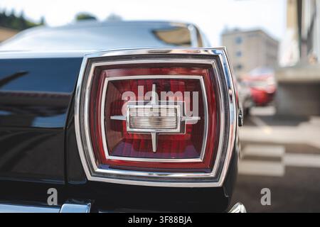 Lindau, Switzerland, August 9, 2026. Close up view of the distinctive square red tail light lens on a black vintage Ford Galaxie classic car model. Stock Photo