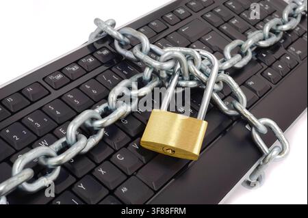 Datenschutz und Datensicherheit Ein Vorhängeschloss mit Kette liegt auf einer Computer-Tastatur als Symbol für Datenschutz und Datensicherheit mit Passwortschutz - FOTOMONTAGE - NUR FÜR REDAKTIONELLE VERWENDUNG - *** Data Protection and Data Security: A padlock with a chain rests on a computer keyboard as a symbol of data protection and data security with password protection. PHOTOMONTAGE FOR EDITORIAL USE ONLY Stock Photo