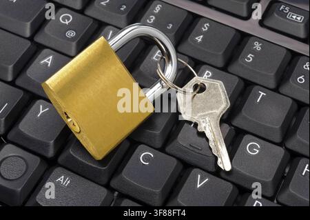 Datenschutz und Datensicherheit Ein Vorhängeschloss liegt auf einer Computer-Tastatur als Symbol für Datenschutz und Datensicherheit mit Passwortschutz - FOTOMONTAGE - NUR FÜR REDAKTIONELLE VERWENDUNG - *** Data Protection and Data Security: A padlock rests on a computer keyboard as a symbol of data protection and data security with password protection. PHOTO MONTAGE FOR EDITORIAL USE ONLY Stock Photo