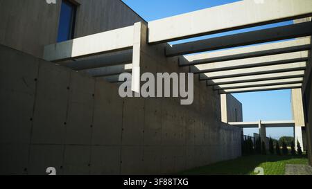 Brutalist concrete architecture featuring minimalist geometric design with shadows under a clear blue sky Stock Photo