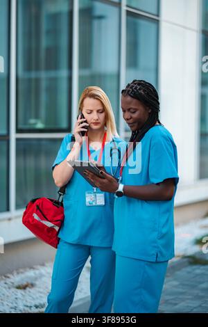 Healthcare professionals collaborating on digital tablet and mobile phone Stock Photo