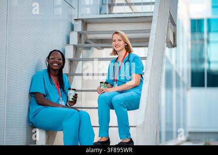 Healthcare workers talking and drinking coffee during break Stock Photo
