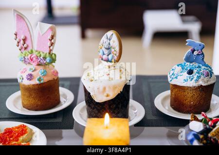 Easter festive table setting with traditional food, cupcakes and red wine at home. Stock Photo