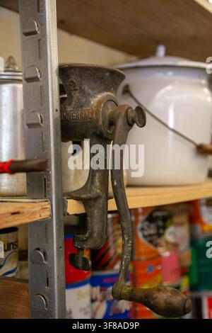 Jumbled collection of miscellaneous metal and plastic kitchen utensils stored inside a domestic drawer, including a metal grater, blue-handled tools Stock Photo
