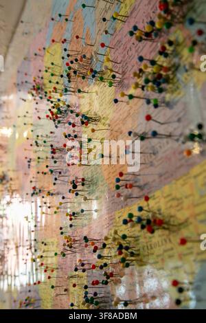 Large wall map of the United States densely covered with hundreds of colorful pushpins marking locations across the country Stock Photo