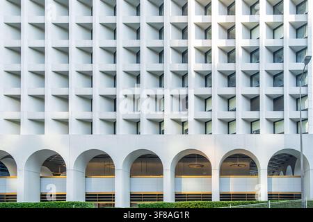 Modern white facade with repetitive windows and architectural arches in Hong Kong city, China. Geometric abstract architecture background, symmetry Stock Photo