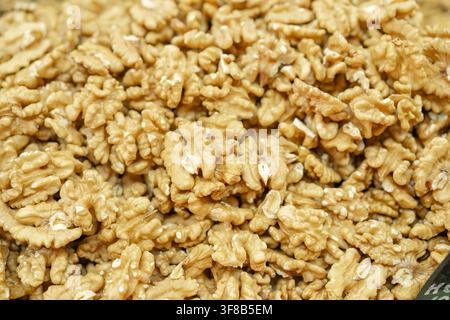 Abundance of fresh shelled golden walnut halves forming a natural food background texture. Perfect for culinary blogs, natural snack advertising Stock Photo