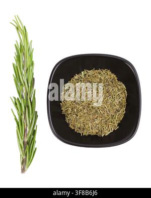 Fresh rosemary sprig and dried rosemary in black bowl isolated on white background Stock Photo