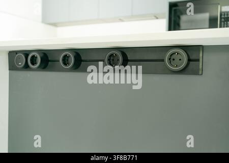 Built-in horizontal socket panel mounted into a kitchen counter for connecting domestic appliances. Perfect stock photo for kitchen ergonomics, home Stock Photo