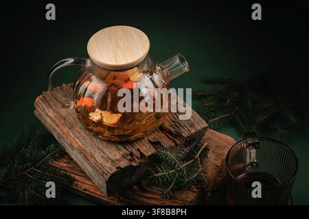 Top View of Herbal Tea in Glass Teapot with Fir Branches and Rustic Wood Stock Photo