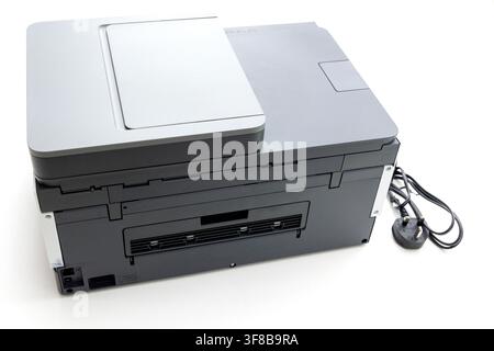 A modern grey multifunction printer stands on a white surface Stock Photo