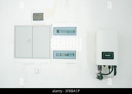 Modern electric control panel setup and heating inverter on a clean wall. Perfect stock image for house utility room, power supply design, residential Stock Photo