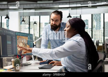 Architectural team using professional CAD tools and rendering software to design a modern home interior layout. Diverse staff working on PC creating 3D modeling assets, construction blueprints. Stock Photo