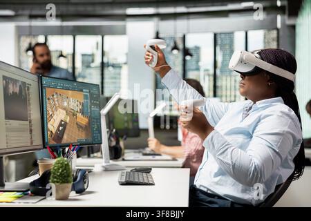 Black architect using CAD software and VR glasses to design architectural floor plan and 3D render on computer. Developer designing layout within virtual reality cyberspace, modeling virtual assets. Stock Photo