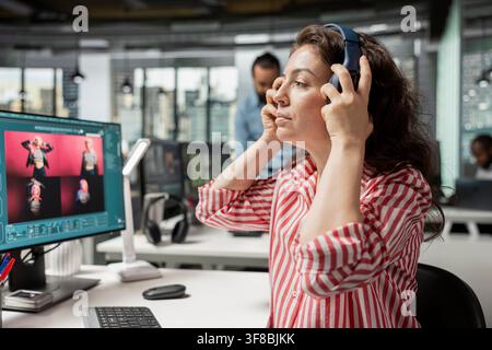 Designer using AI tech generative models and listening to music, using chatbot to produce visuals for editorial catalog. Woman editing photography and generating images from prompts, headset. Stock Photo