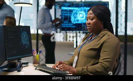 Female technician writing code on PC, developing neural networks APIs. System administrator using computer to troubleshoot software errors with artificial intelligence technology, camera A Stock Photo