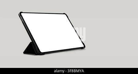Empty tablet computer screen mockup with black case standing on light grey background Stock Photo