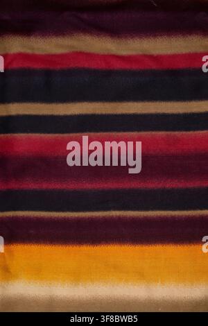 Vertical Colorful Striped Fabric Texture Background with warm red, yellow, black, and beige tones, ideal for textile, fashion, traditional cloth Stock Photo