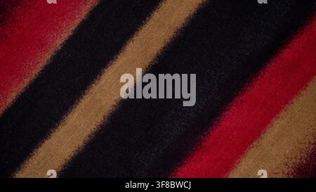 folded colorful fabric with red, black, beige, and yellow tones, suitable for textile, clothing, craft, fashion, and abstract background concepts. Stock Photo
