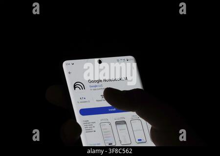A hand holding a smartphone with the Google NotebookLM app open on the screen Stock Photo