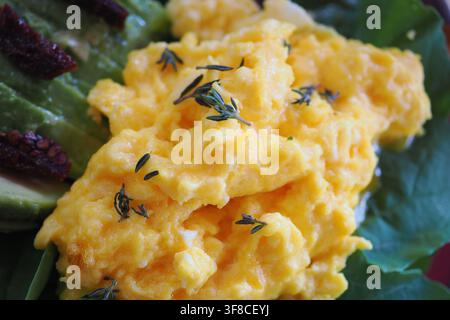 Scrambled eggs and greens served on a plate Stock Photo