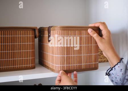 Person organizing baskets on a shelf in a home Stock Photo