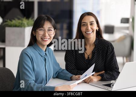 Diverse businesswomen reviewing financial charts or report together Stock Photo