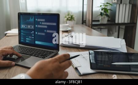 Person uses LLM-based AI chatbot software on a laptop documents, interacting with a digital AI Assisted Home Office interface to organize tasks and su Stock Photo
