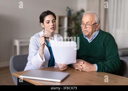 Young adult doctor consulting senior patient on medical documents Stock Photo