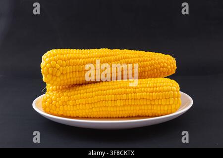 Boiled yellow waxy sweet corn cobs stack isolated on white background Stock Photo