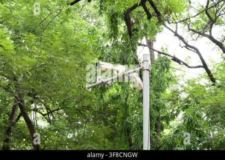 Outdoor security surveillance cameras mounted on pole in green park landscapes Stock Photo