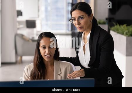 Multiethnic team members reviewing information on computer screen Stock Photo