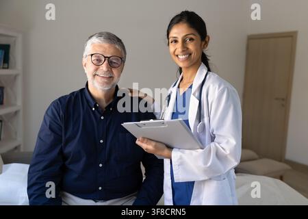 Smiling female doctor posing for portrait with senior male patient Stock Photo