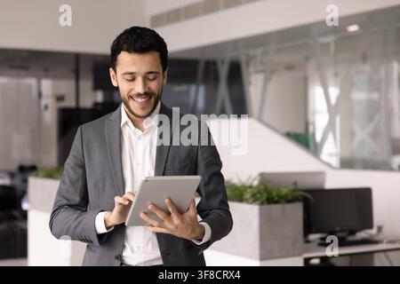 Workflow of young adult Arab businessman using digital tablet Stock Photo